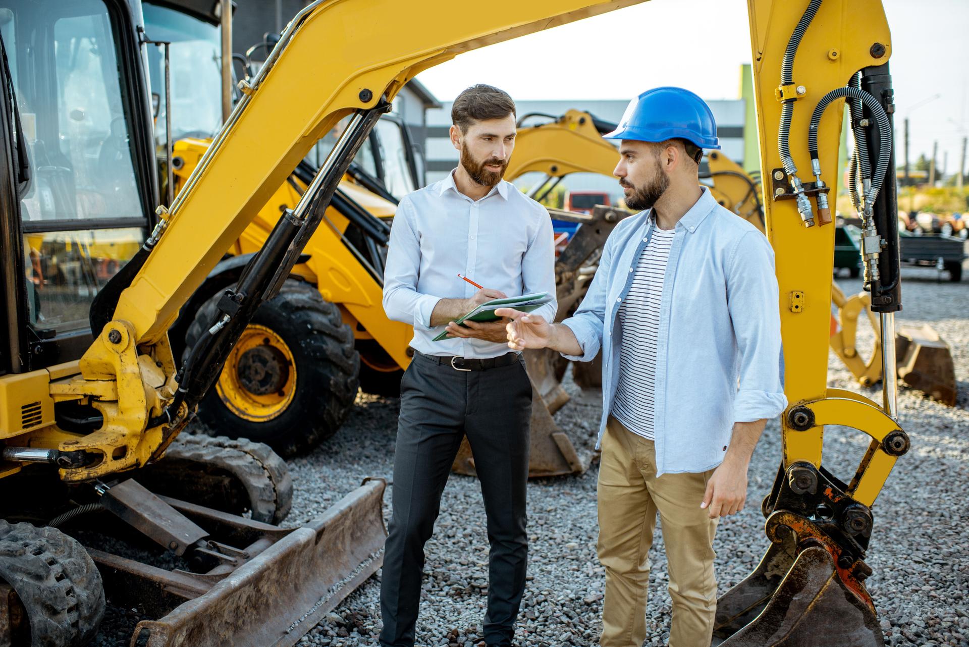 Builder with a sales consultant at the shop with heavy machinery